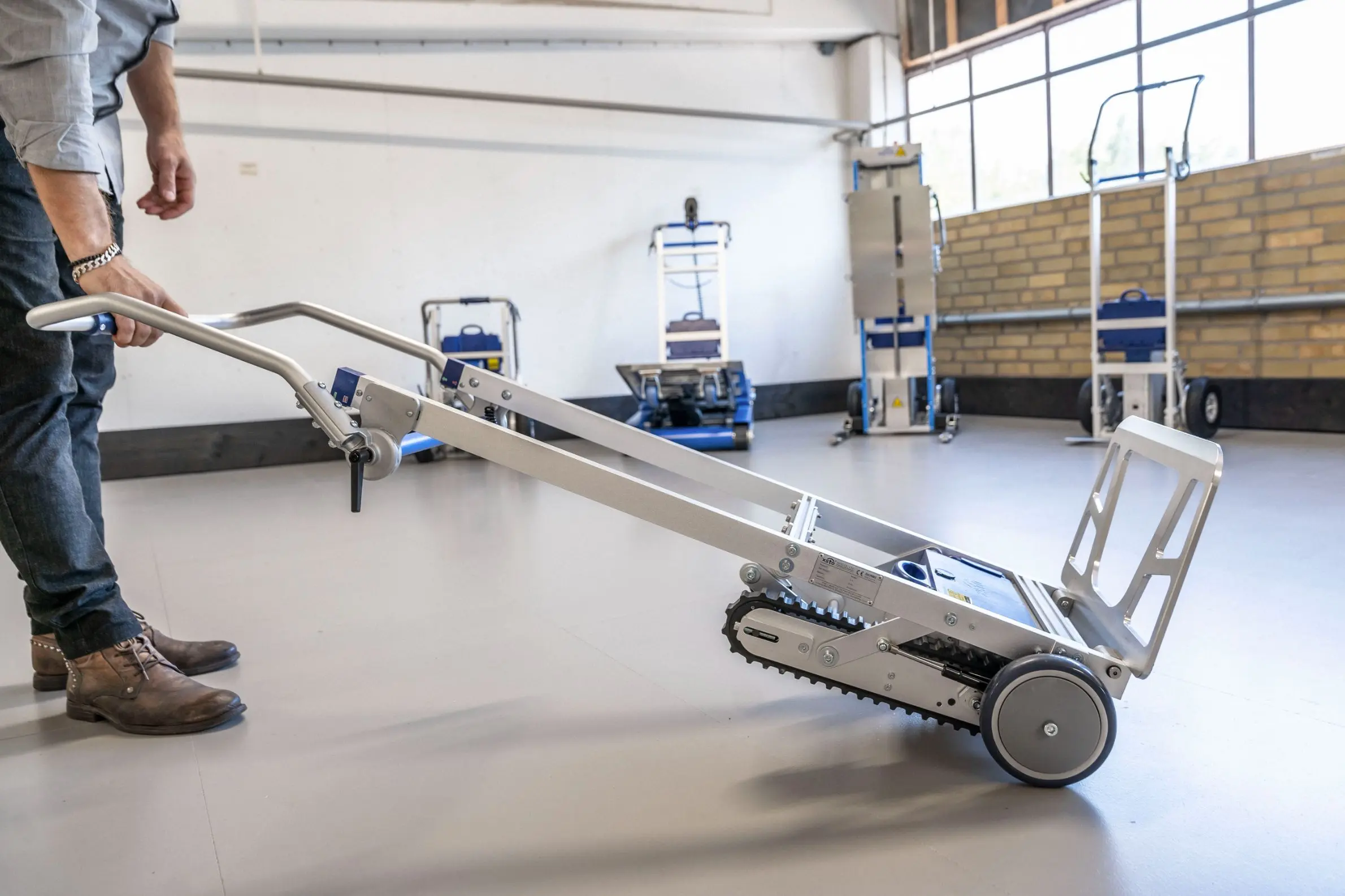 En man använder en trappklättrare i ett lager